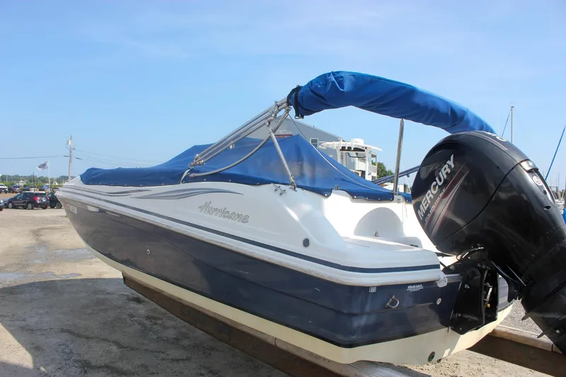 Slide: The Image of 2013 Hurricane SunDeck Sport 188 OB boat with blue cover and Mercury outboard motor. - 5
