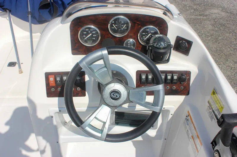 Slide: The Image of 2013 Hurricane SunDeck Sport 188 OB boat dashboard with steering wheel and control panel. - 6