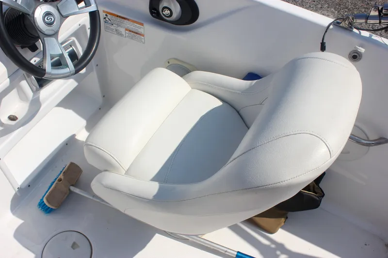 Slide: The Image of 2013 Hurricane SunDeck Sport 188 OB boat interior with white captain's chair and steering wheel. - 9