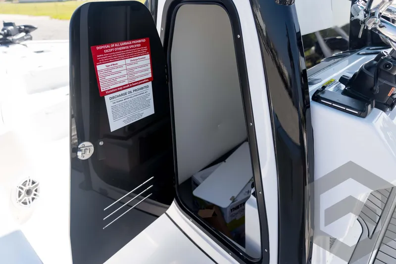 Slide: The Image of 2026 Tidewater 2410 Bay Max boat interior with open storage compartment door. - 32