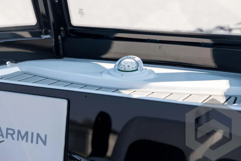 Slide: The Image of 2026 Tidewater 2410 Bay Max boat dashboard with compass and Garmin equipment. - 36