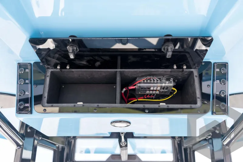 Slide: The Image of 2026 Tidewater 2410 Bay Max boat console with open storage compartment and wiring. - 56