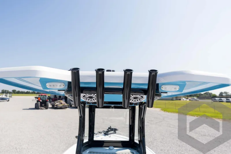 Slide: The Image of 2026 Tidewater 2410 Bay Max boat with T-top and rod holders, parked outdoors. - 74