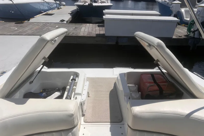 Slide: The Image of Open storage compartments on a 2003 Cobalt 263 boat at a marina dock. - 2