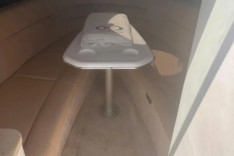 Slide: The Image of Interior of a 2003 Cobalt 263 boat with beige seating and a central table. - 21
