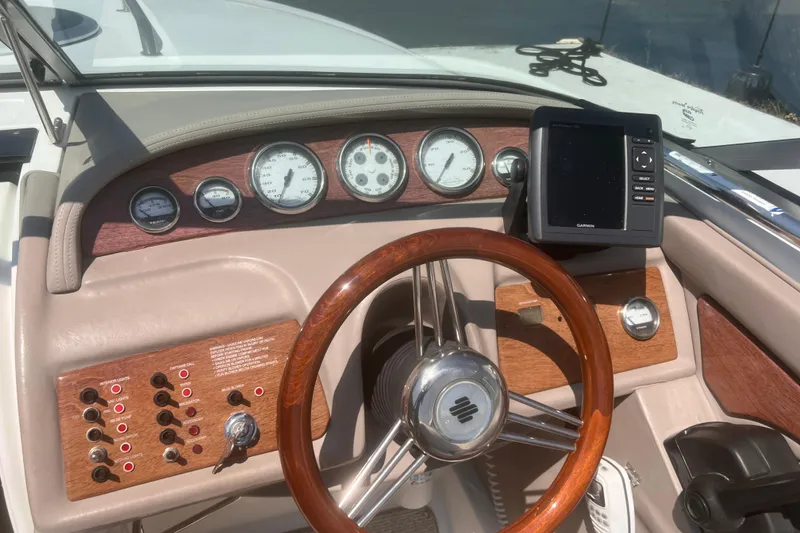 Slide: The Image of Dashboard of a 2003 Cobalt 263 boat with gauges and a wooden steering wheel. - 29