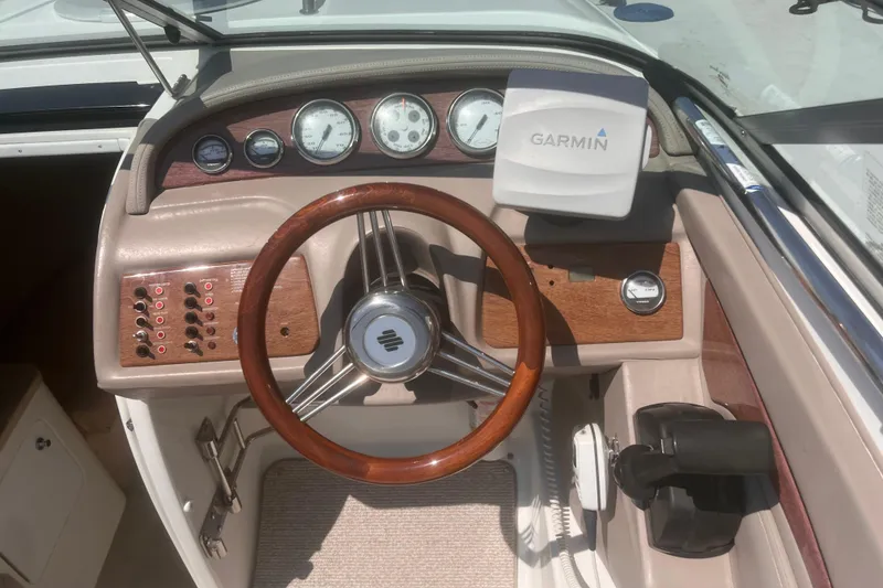 Slide: The Image of Boat dashboard with wooden steering wheel, Garmin GPS, and control panel. Coblat 263, 2003 model. - 8