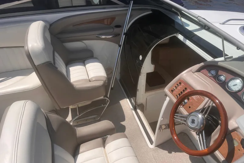 Slide: The Image of Interior of a 2003 Cobalt 263 boat with beige seating and wooden steering wheel. - 9
