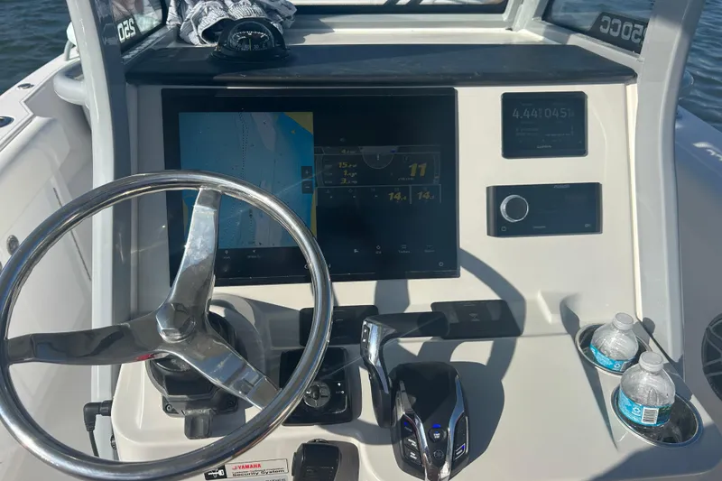 Slide: The Image of 2026 Edgewater 250 CC boat dashboard with steering wheel, navigation screen, and controls. - 4