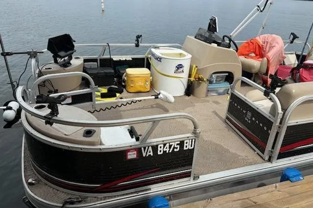 Slide: The Image of 2013 Sun Tracker Fishing Barge 22 pontoon boat docked, equipped for fishing. - 3