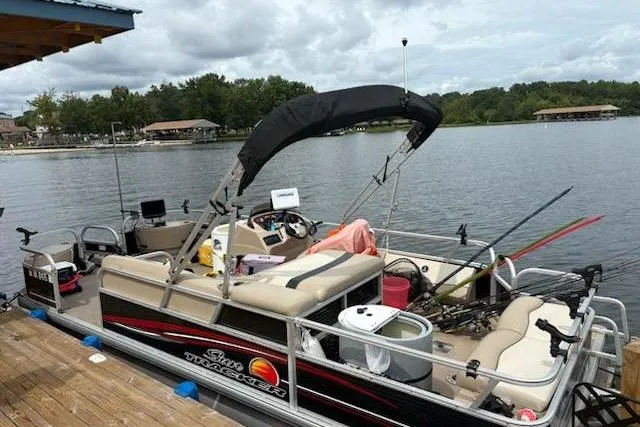 Slide: The Image of 2013 Sun Tracker Fishing Barge 22 docked on a serene lake, equipped for fishing. - 6