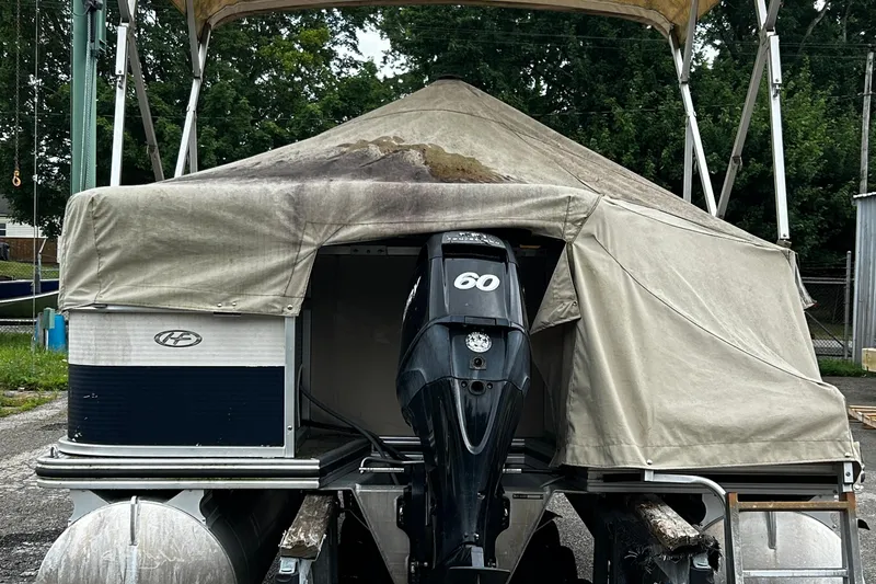 Slide: The Image of 2009 Harris CRUSIER 220 boat with covered canopy and 60 HP outboard motor. - 2