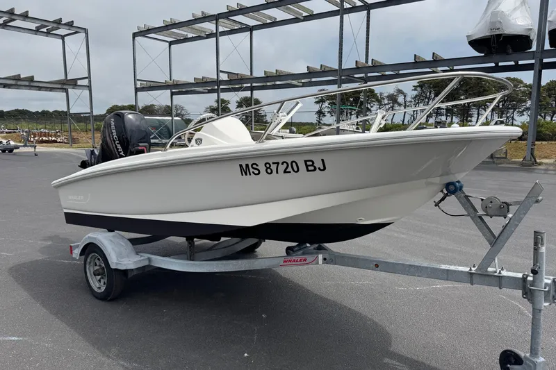 Slide: The Image of 2018 Boston Whaler 130 Super Sport boat on trailer in parking lot. - 3