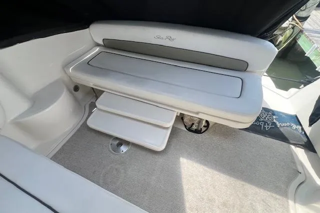 Slide: The Image of 2006 Sea Ray 300 Sundancer interior seating with steps, featuring sleek white upholstery. - 13