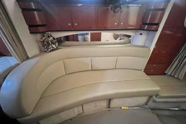 Slide: The Image of 2006 Sea Ray 300 Sundancer interior with beige leather seating and wooden cabinets. - 16