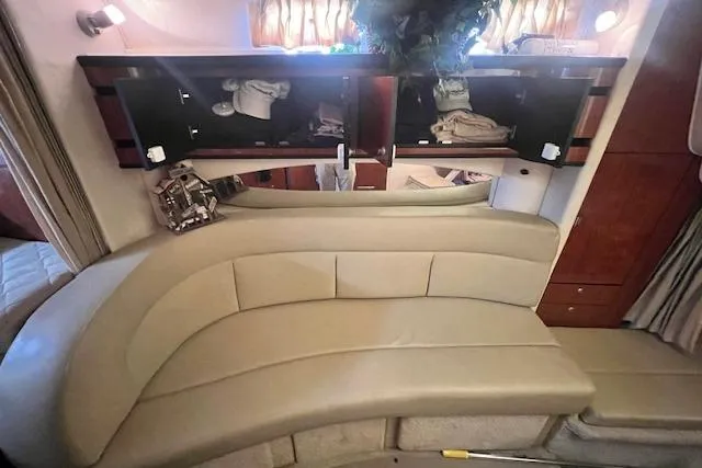 Slide: The Image of Interior of 2006 Sea Ray 300 Sundancer with beige seating and overhead storage. - 17