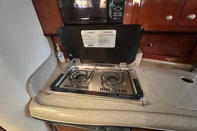 Slide: The Image of 2006 Sea Ray 300 Sundancer galley with stove and countertop. - 20