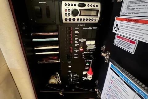 Slide: The Image of Control panel inside a 2006 Sea Ray 300 Sundancer boat, featuring various switches and a stereo system. - 27