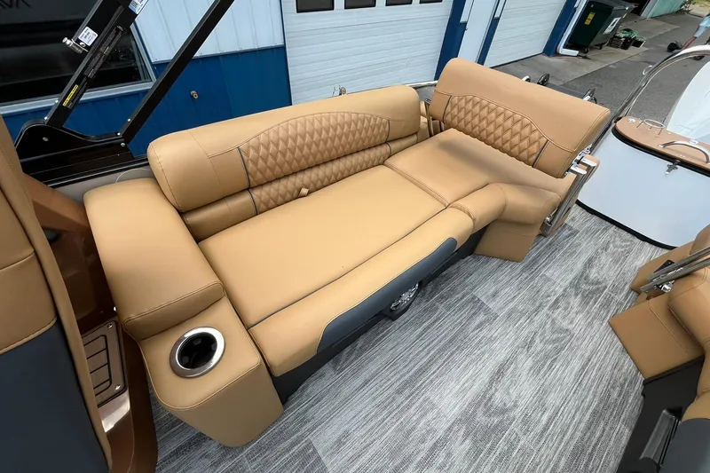 Slide: The Image of Luxurious tan seating on 2025 Avalon Catalina Quad Lounger boat, featuring cup holders and stylish design. - 16