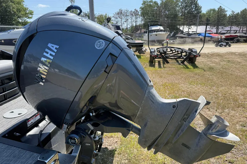 Slide: The Image of 2024 Bennington 23LSB with Yamaha outboard motor in a boatyard setting. - 10