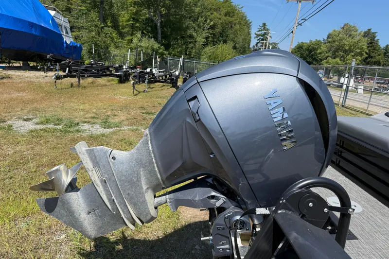 Slide: The Image of 2024 Bennington 23LSB boat with Yamaha outboard motor in a grassy area. - 12