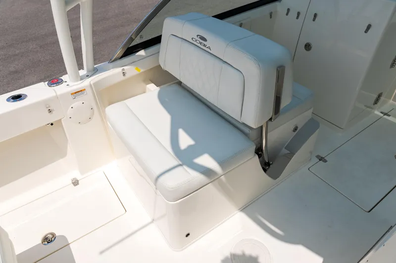 Slide: The Image of Storage compartment on 2023 Cobia 240 Dual Console boat, featuring a clean, white interior. - 16