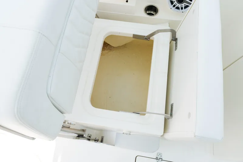 Slide: The Image of 2023 Cobia 240 Dual Console boat interior with compact marine toilet and sink. - 18