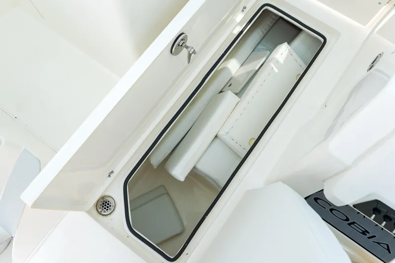 Slide: The Image of 2023 Cobia 240 Dual Console boat cockpit with Garmin navigation and white seating. - 22
