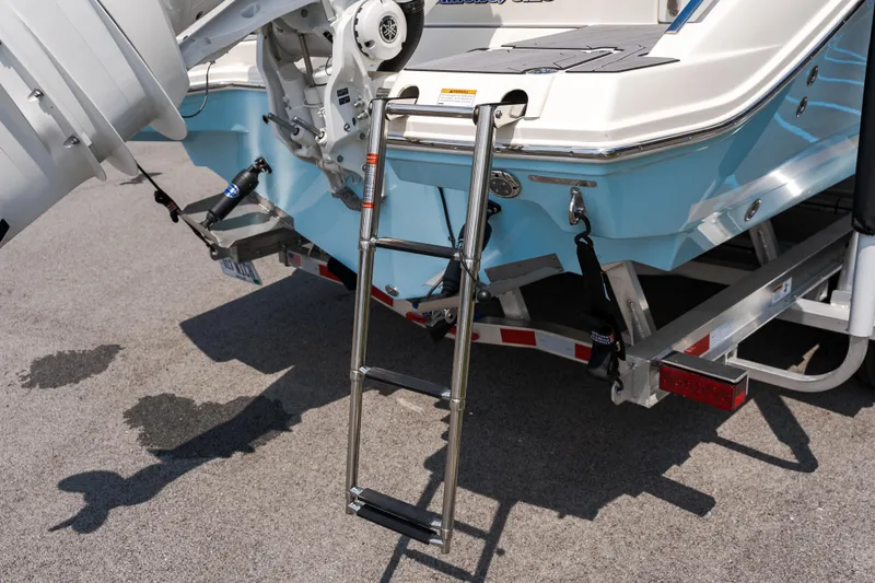 Slide: The Image of 2023 Cobia 240 Dual Console boat interior with seating and storage, parked in a lot. - 5