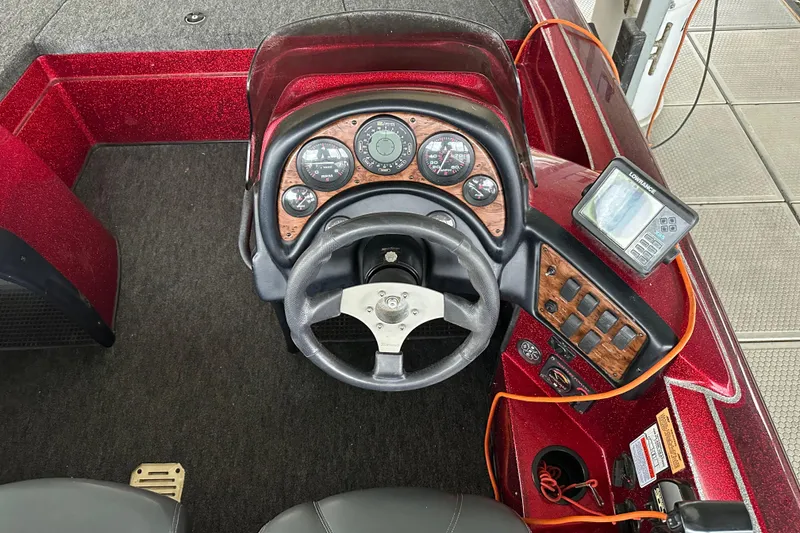 Slide: The Image of 1999 Tracker Bass Tracker 896 DC boat dashboard with steering wheel and control panel. - 2