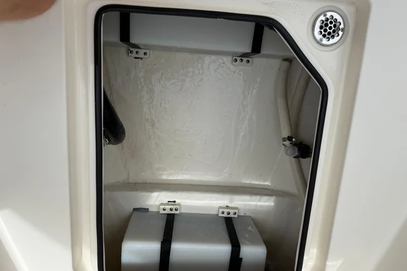 Slide: The Image of 2022 Cobia 240 Center Console storage compartment with secured equipment and ventilation. - 19