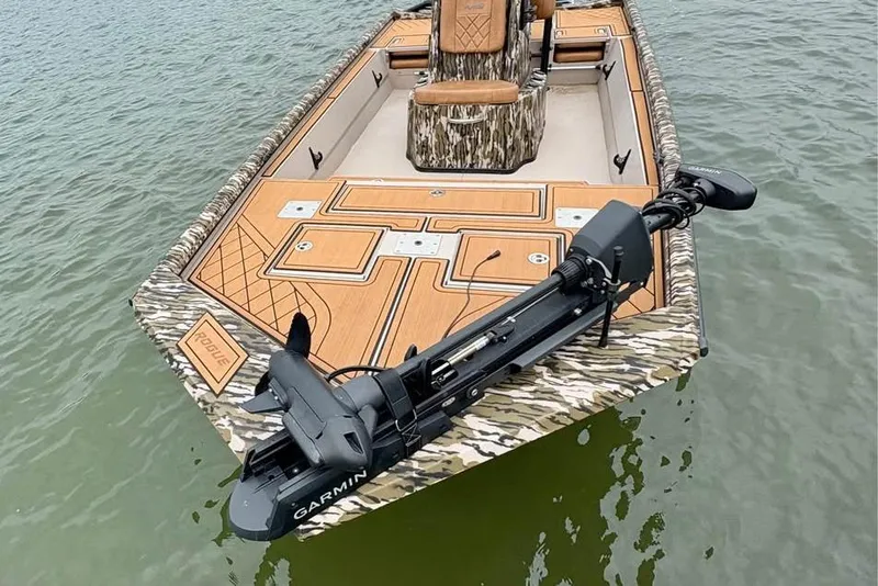 Slide: The Image of 2024 Avid 20 Rogue boat with camouflage design and Garmin equipment on water. - 1