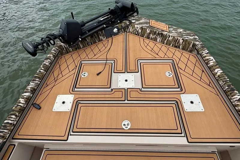 Slide: The Image of 2024 Avid 20 Rogue boat deck with camo trim and mounted equipment on water. - 3