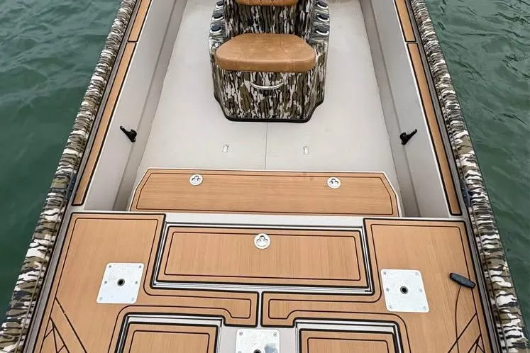 Slide: The Image of 2024 Avid 20 Rogue boat interior with camo seating and wood-patterned deck. - 4