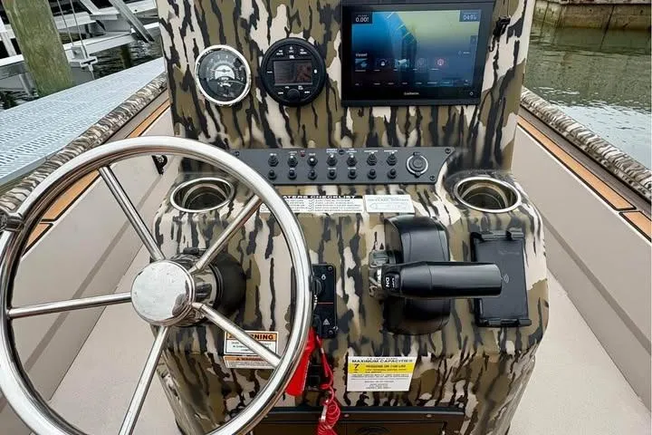 Slide: The Image of Boat dashboard of 2024 Avid 20 Rogue with camouflage design and modern controls. - 5