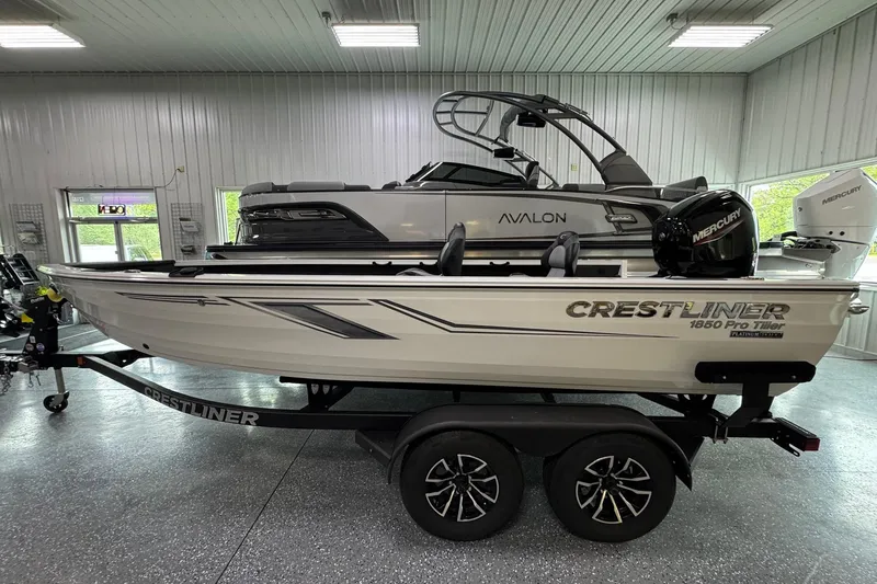 The Image of 2025 Crestliner 1850 Pro Tiller boat on trailer in showroom. - 1