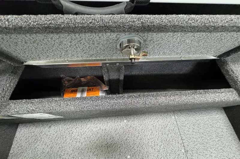 Slide: The Image of Storage compartment of 2025 Crestliner 1850 Pro Tiller boat, featuring secure latch and interior space. - 12