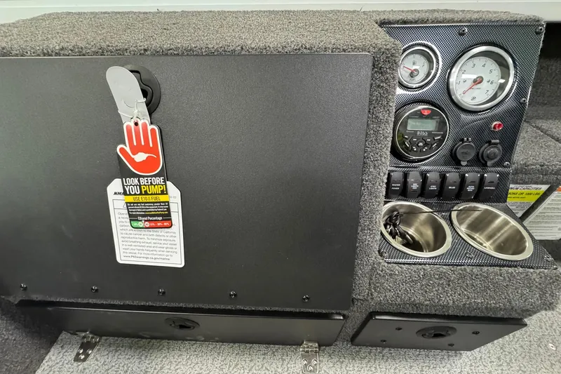 Slide: The Image of 2025 Crestliner 1850 Pro Tiller dashboard with gauges, warning tag, and cup holders. - 13