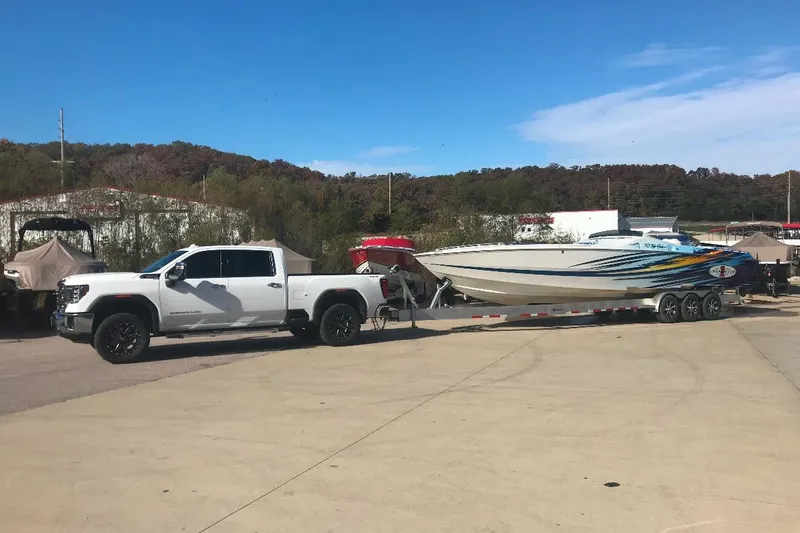 Slide: The Image of White truck towing 2001 Cigarette 38 Top Gun boat on a trailer in a parking lot. - 11