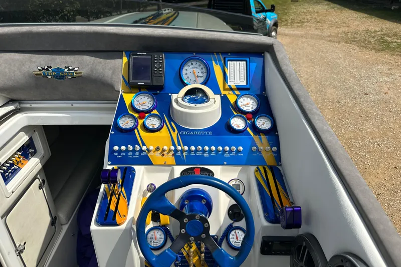 Slide: The Image of 2001 Cigarette 38 Top Gun boat dashboard with blue and yellow gauges and controls. - 18