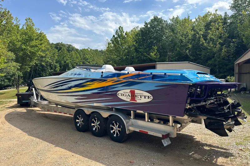 Slide: The Image of 2001 Cigarette 38 Top Gun speedboat on trailer, vibrant paint, parked outdoors. - 3