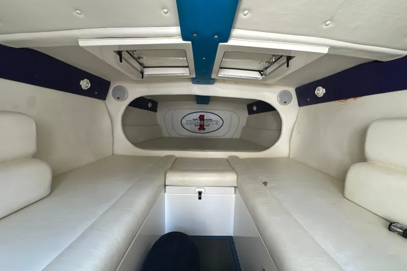 Slide: The Image of Interior of a 2001 Cigarette 38 Top Gun boat with white seating and blue accents. - 32
