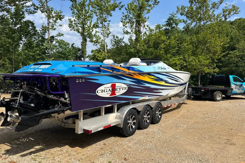 Slide: The Image of 2001 Cigarette 38 Top Gun speedboat on trailer, vibrant design, parked outdoors. - 4