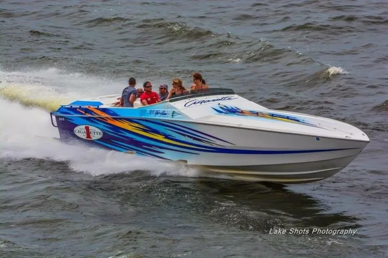 Slide: The Image of 2001 Cigarette 38 Top Gun speedboat with colorful graphics cruising on water. - 8