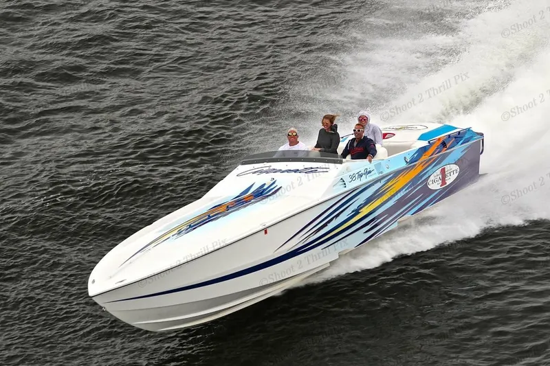 Slide: The Image of 2001 Cigarette 38 Top Gun speedboat cruising on water with passengers, vibrant graphics. - 9