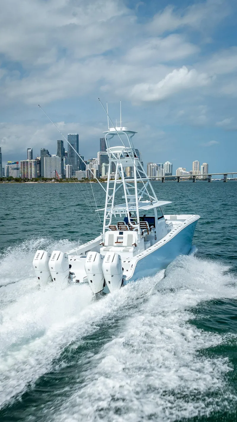 Slide: The Image of 2024 Freeman NEW QUAD V10s 400 HP boat cruising on the ocean near a city skyline. - 46