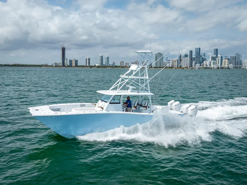 Slide: The Image of 2024 Freeman NEW QUAD V10s 400 HP boat cruising on water near city skyline. - 49