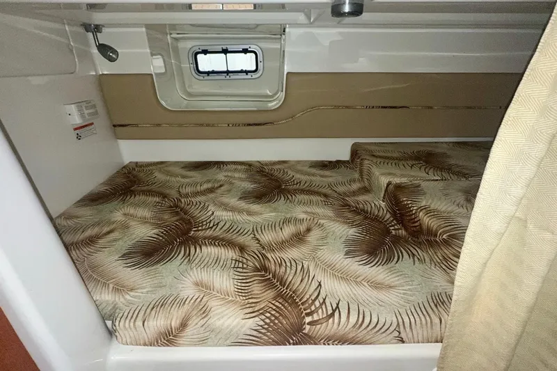 Slide: The Image of 2006 Pro-Line 32 Express cabin with patterned bedding and small window. - 16