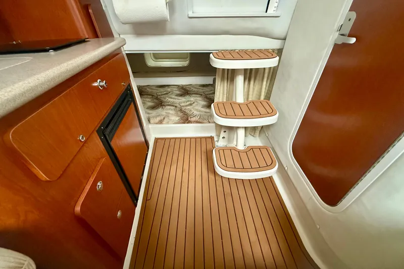Slide: The Image of 2006 Pro-Line 32 Express cabin interior with wooden flooring and compact kitchenette. - 19
