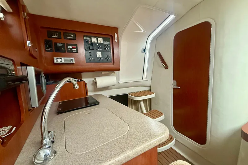 Slide: The Image of Interior of 2006 Pro-Line 32 Express boat featuring a compact kitchen area. - 20